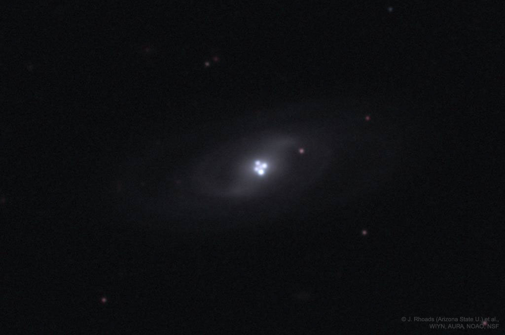 Zdjęcie pokazuje pojedynczy odległy kwazar, który wydaje się
poczwórny ze względu na efekt soczewkowania grawitacyjnego oddziałującej
galaktyki. Zobacz opis. Po kliknięciu na obrazek załaduje się wersja
 o największej dostępnej rozdzielczości.