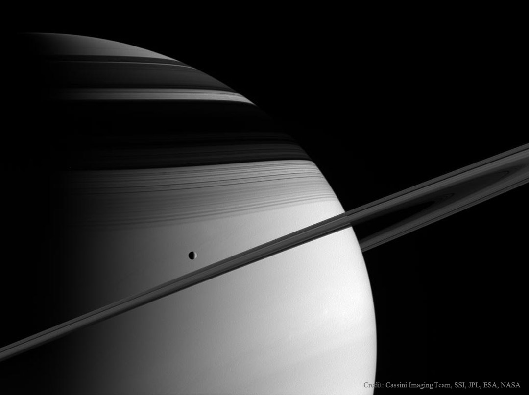 Prezentowane zdjęcie przedstawia Saturna, jego pieścienie, widoczne niemal dokładnie z boku, ich cienie na tarczy planety oraz 
lodowy księżyc Tetydę. Zdjęcie wykonane zostało przez sondę Cassini w 2005 roku.
Więcej szczegółowych informacji w opisie poniżej.
