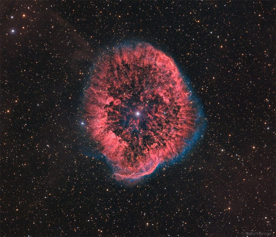 Czerwony owal oraz tekstura mgławicy otoczone są słabą, niebieską poświatą. W jej środku widoczna jest jasna gwiazda, podczas gdy tło zdjęcia wypełnia wiele słabych gwiazd. 
Więcej szczegółowych informacji w opisie poniżej.
