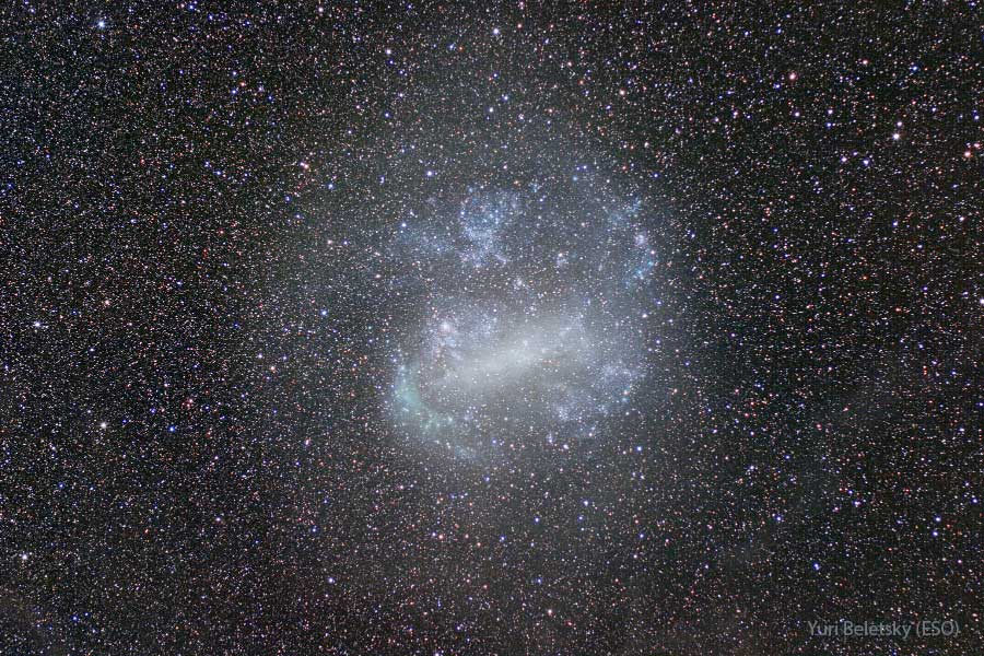 Przedstawiona galaktyka wydaje się głównie niebiesko-biała, a przez jej środek biegnie wydatna poprzeczka.
Galaktyka to Wielki Obłok Magellana. Na zdjęciu widać również tysiące słabych gwiazd naszej Drogi Mlecznej.
Więcej szczegółowych informacji w opisie poniżej.