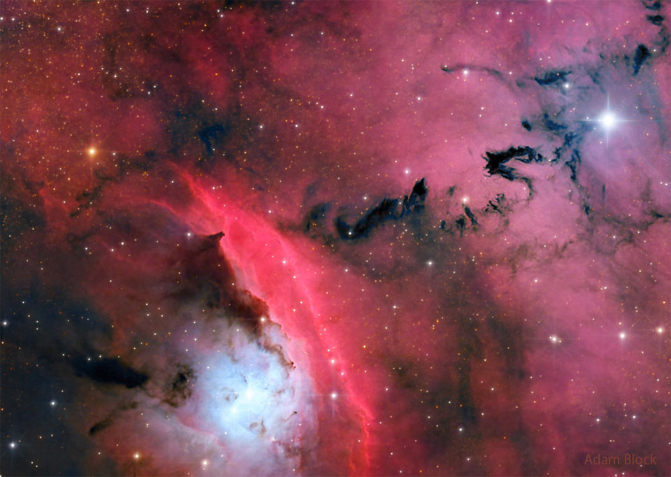 A busy star formation region is shown highlighted by red glowing clouds
and dark ominously-shaped dust.
Więcej szczegółowych informacji w opisie poniżej.