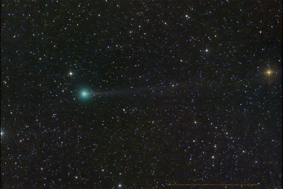 A dark starfield is shown with a dim green blur in the middle.
Faintly extending from the green blur is a tail toward the left.
Więcej szczegółowych informacji w opisie poniżej.