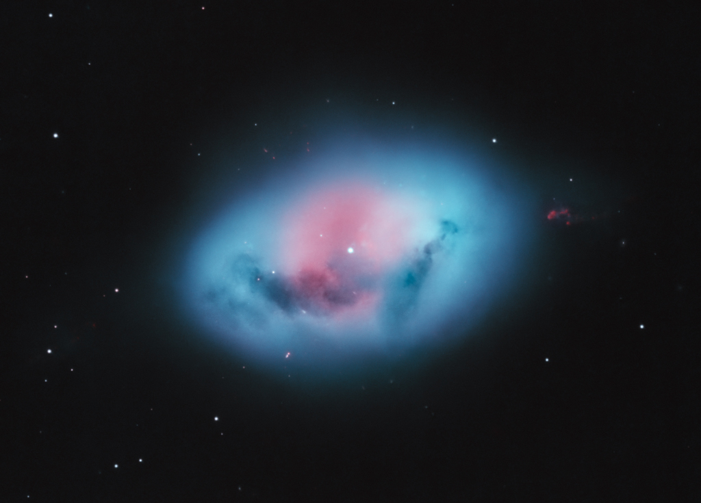 Pokazano galaktykę spiralną z wieloma rozbudowanymi
czerwonymi włóknami. Zobacz opis. Po kliknięciu
obrazka załaduje się wersja o największej
dostępnej rozdzielczości.