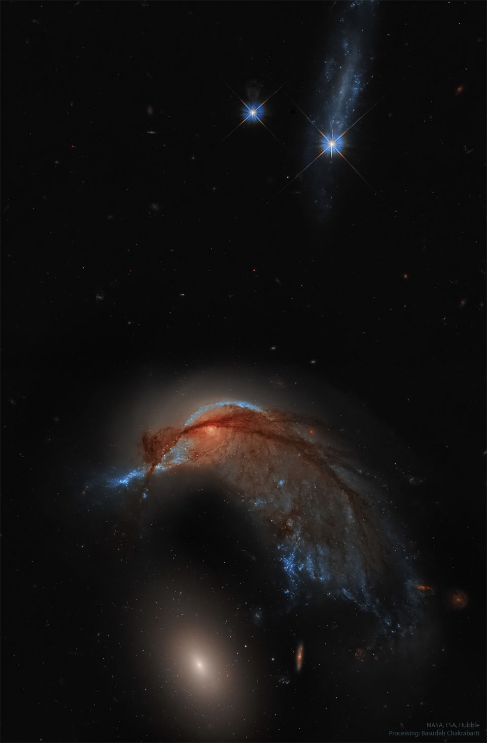 Na zdjęciu widzoczne jest pole gwiazd z dwiema jasnymi
gwiazdami na górze kadru i dwiema galaktykami na dole. Górna
galaktyka jest galaktyką spiralną, której wygląd przypomina kolibra.
Dolna galaktyka to zwykła galaktyka eliptyczna
Zobacz opis. Po kliknięciu obrazka załaduje się wersja o największej
dostępnej rozdzielczości.