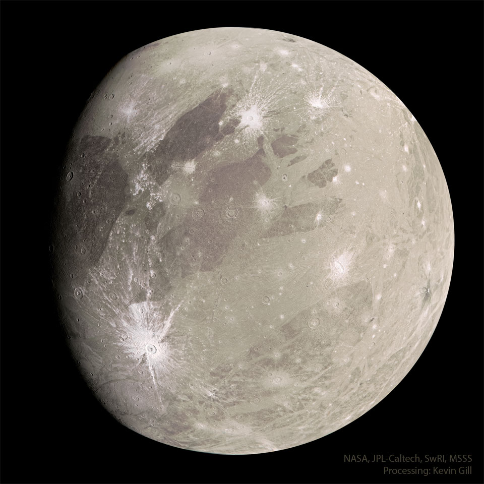 A tan sphere is shown with dark markings and a few light craters.
The sphere is the largest known moon in the Solar System: Jupiter's
moon Ganymede.
Więcej szczegółowych informacji w opisie poniżej.