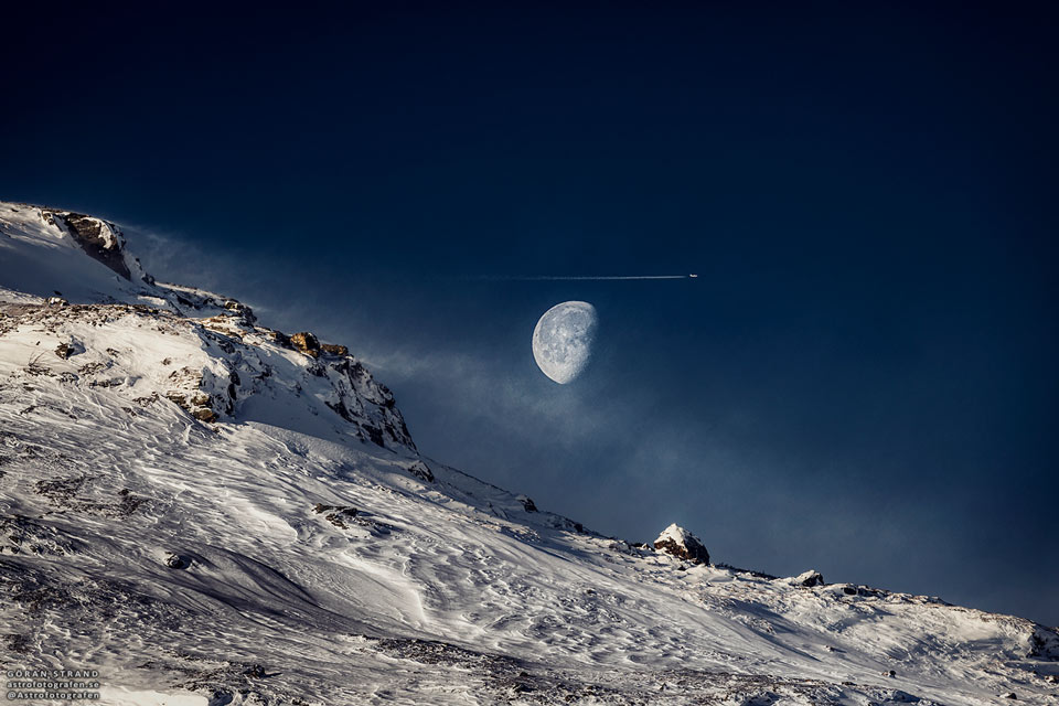 Na zdjęciu widać Księżyc przed ostatnią kwadrą nad zaśnieżonym
stromym wzgórzem. Tuż nad Księżycem znajduje się samolot
i smugi kondensacyjne. Zobacz opis. Po kliknięciu obrazka załaduje się wersja
 o największej dostępnej rozdzielczości.