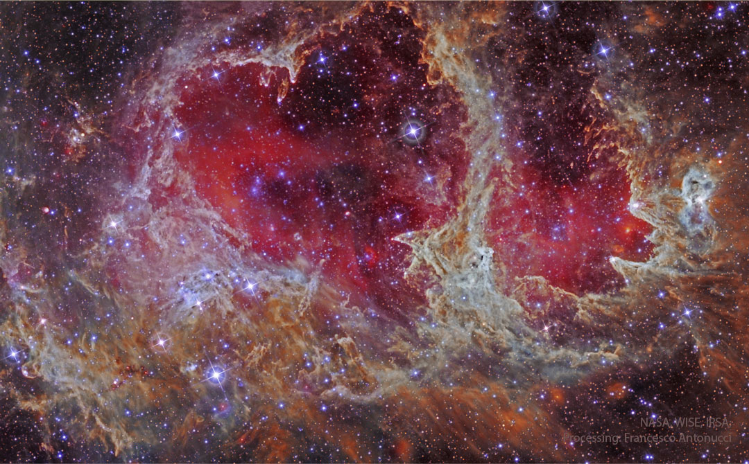 A star field is shown in infrared light. In the center
is an extremely complex nebula that is outlines an iconic
heart. Glowing gas shades the center of the heart red.
Więcej szczegółowych informacji w opisie poniżej.