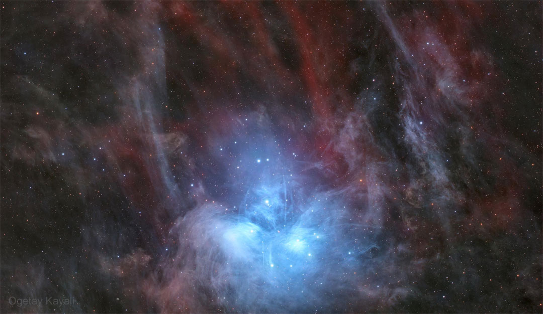 A cluster of bright blue stars is seen near the bottom
of this starfield. Nebula around the stars is blue near
the stars but red elsewhere. 
Więcej szczegółowych informacji w opisie poniżej.