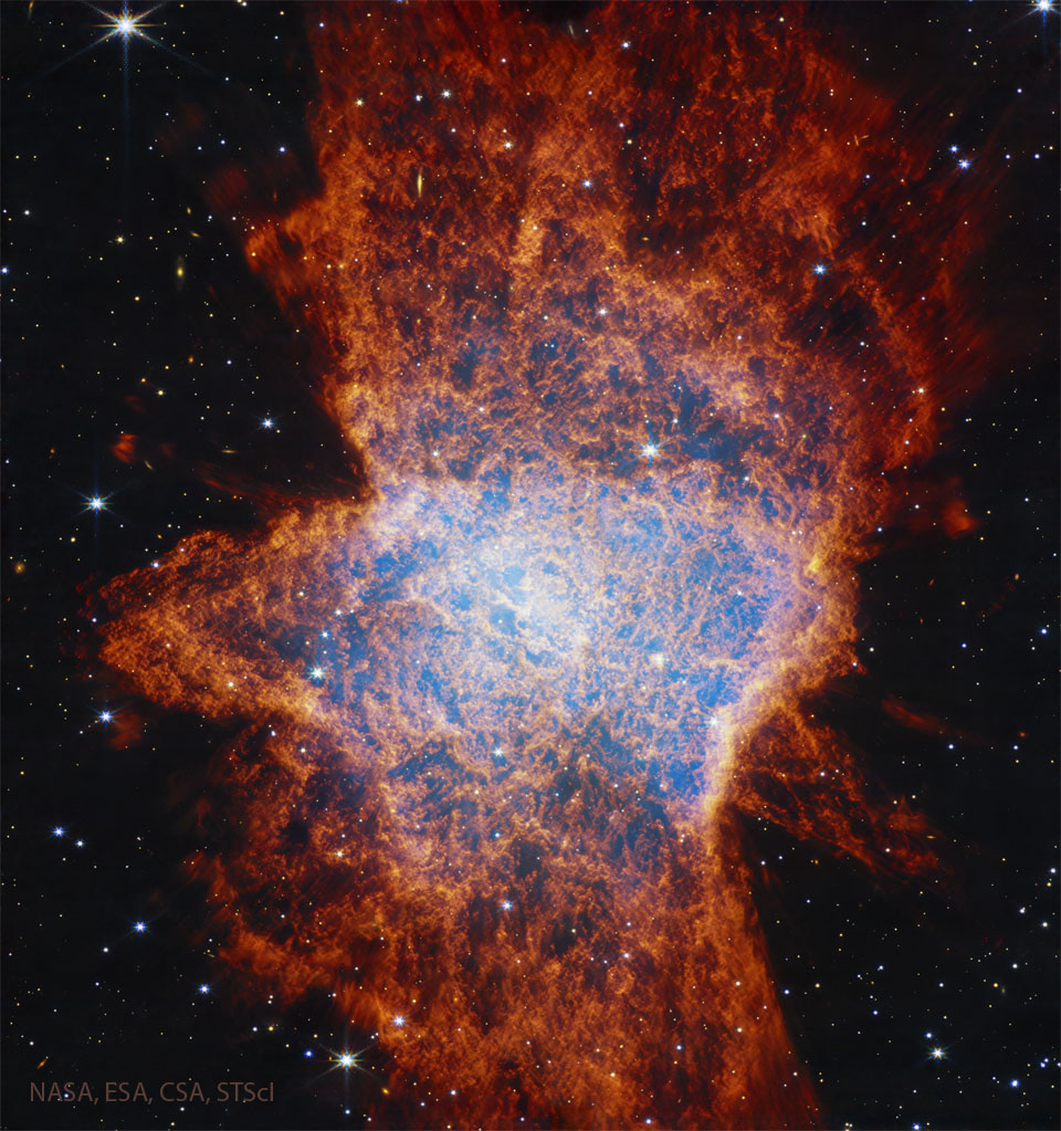 A starfield is shown dominated by a complex
nebula shown with many red filaments and with a
light glow in a region near the center. 
Więcej szczegółowych informacji w opisie poniżej.