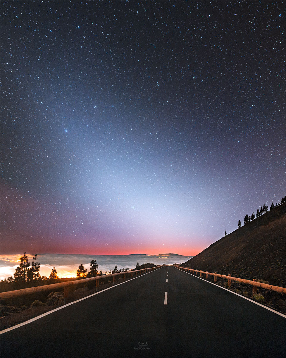 A night sky is shown above a road going off into
the distance. An unusual area of brightened sky that 
does not block background stars appears diagonally
from the lower right across the sky.
Więcej szczegółowych informacji w opisie poniżej.