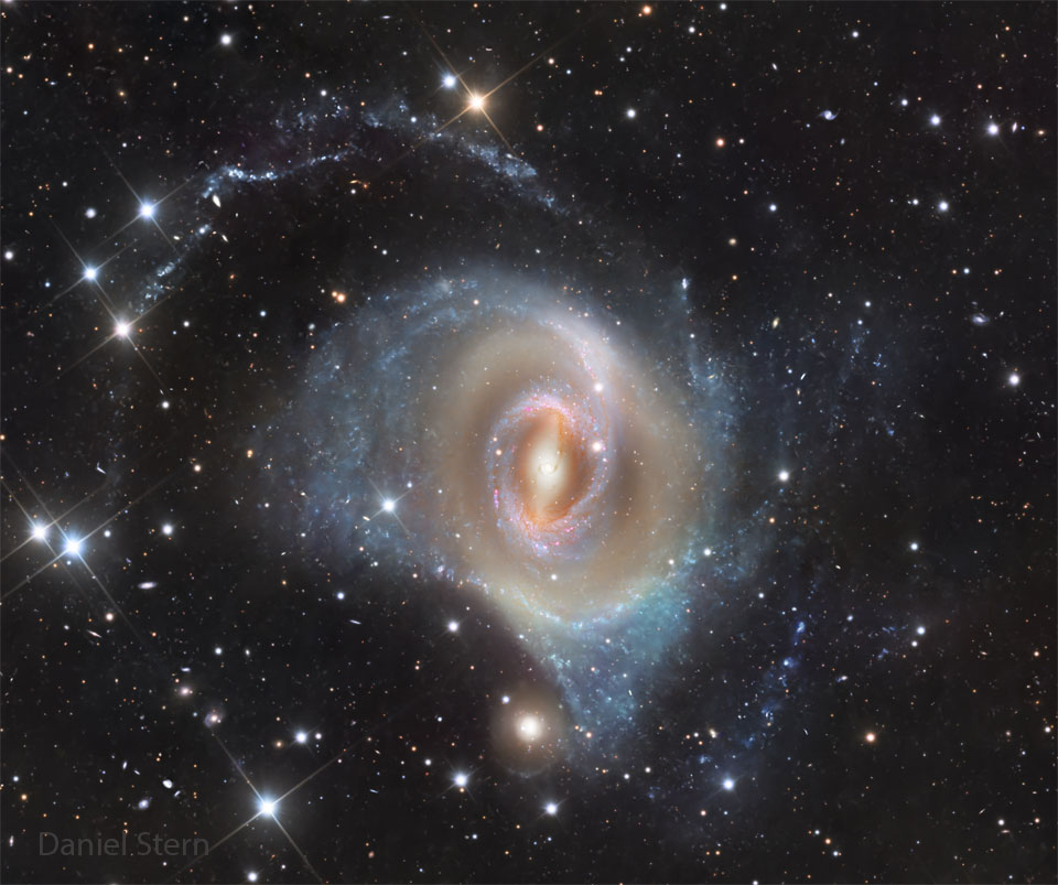 A spiral galaxy is shown that seems to have rings
in place of spiral arms. The outer ring is blue and filled
with stars, while the inner ring is more red. The center
has a vertical bar.
Więcej szczegółowych informacji w opisie poniżej.