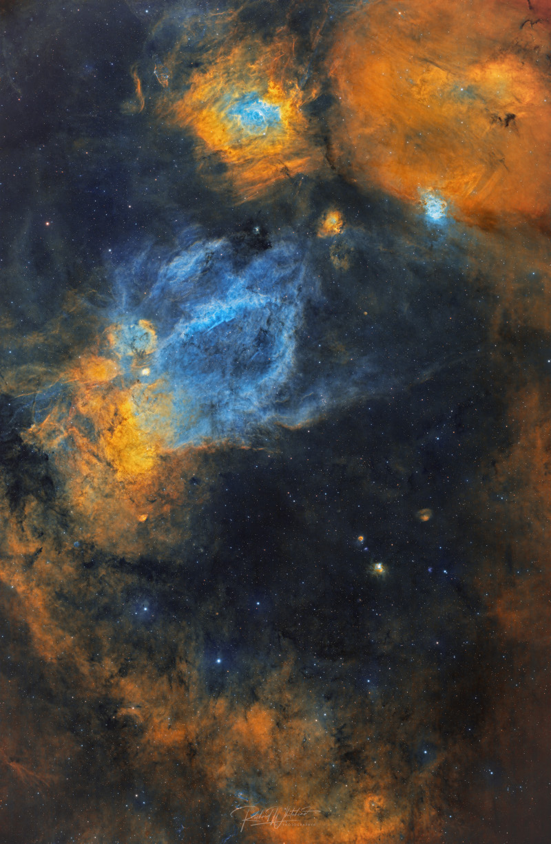 Large clouds of interstellar gas and dust of various shapes and sizes cover the image. A cloud shaped like a bubble 
sits atop the image, while a cloud shaped like a claw is in the middle.