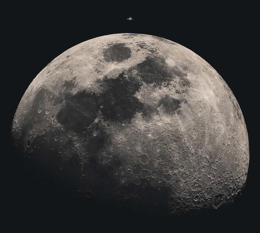 The relatively small International Space Station sits atop the image, about to transit in front of the
illuminated Moon. Więcej szczegółowych informacji w opisie poniżej.