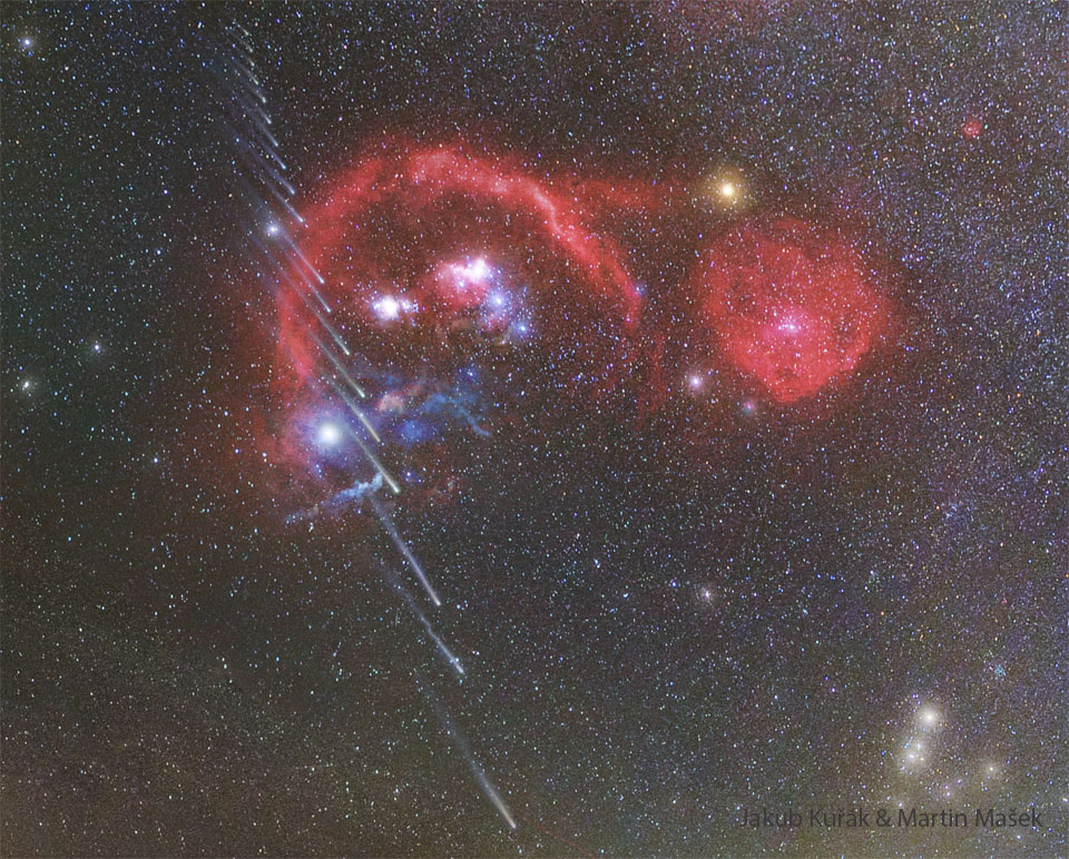 A starfield shows many red nebulas near the center. 
Running vertically up the left side are about 20 images of a
comet, with the head towards the image bottom.  Successively
higher images of the comet show successively shorter
tails. 
Więcej szczegółowych informacji w opisie poniżej.